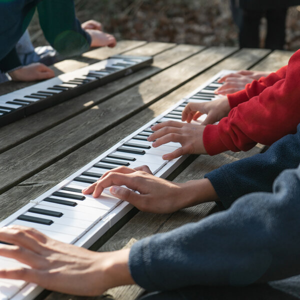 image of people playing carry-on pianos outside