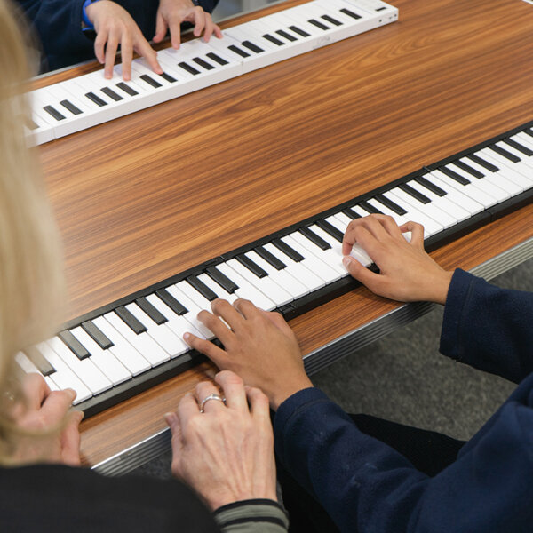 Students learning on Carry-On pianos